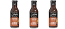 Three bottles of G. Hughes Teriyaki Marinade and Sauce are displayed, featuring a dark brown liquid in a clear bottle with a black cap, labeled as zero sugar and gluten-free.
