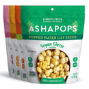 Four colorful bags of Ashapops popped water lily seeds are displayed, with the front bag highlighting vegan cheese flavor, featuring a bowl of the snack and nutrition details.